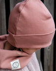 Kuschelig weicher Loop Schal aus GOTS-zertifizierter Bio-Baumwolle in unserer exklusiven Farbe Dusty Rose. Die Beanie ist aus fein geripptem und sehr elastischem Stoff, sodass die Mütze mit wächst und Ihr lange Freude daran haben werdet. Kreiere perfekte Looks indem Du die Beanie mit unseren Schühchen, Leggings und Schals kombinierst!