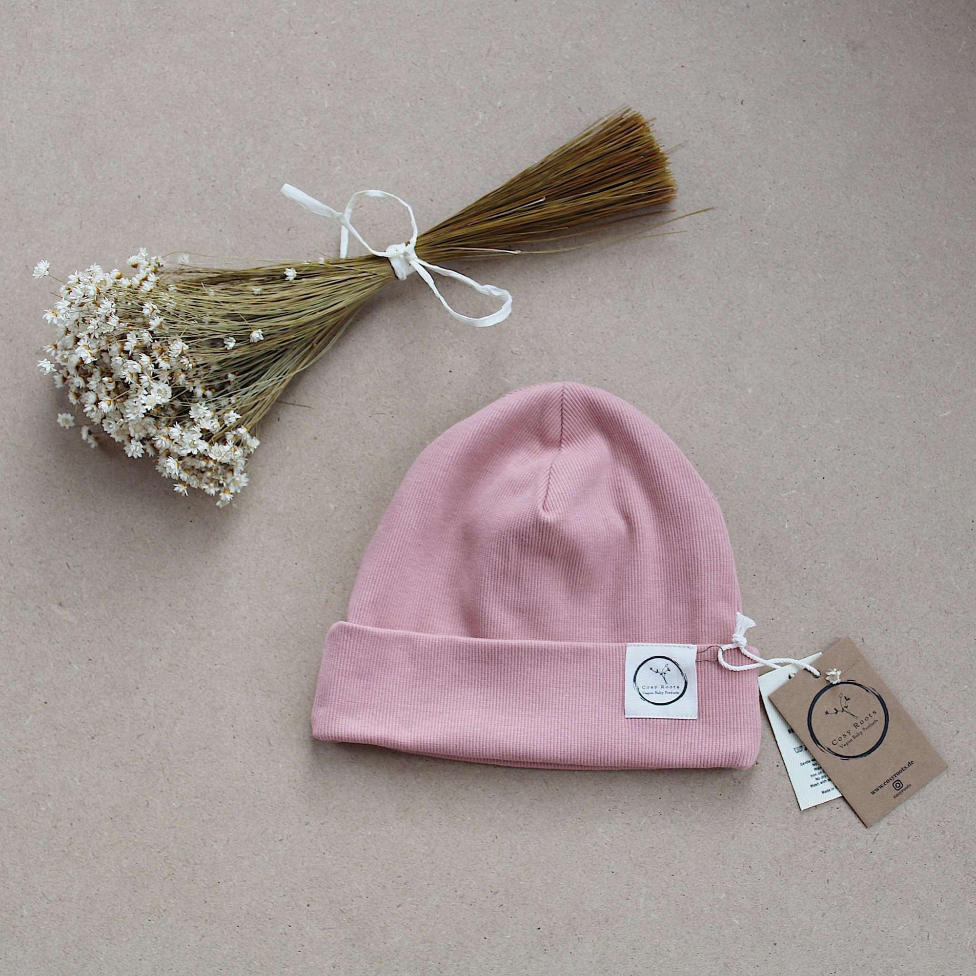 Kuschelig weiche Beanie aus GOTS-zertifizierter Bio-Baumwolle in unserer exklusiven Farbe Dusty Rose.  Die Beanie ist aus fein geripptem und sehr elastischem Stoff, sodass die Mütze mit wächst und Ihr lange Freude daran haben werdet.  Kreiere perfekte Looks indem Du die Beanie mit unseren Schühchen, Leggings und Schals kombinierst!
