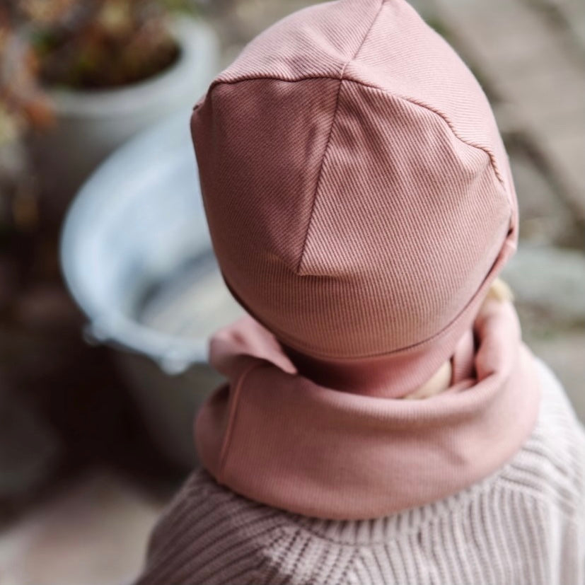 Kuschelig weiche Beanie aus GOTS-zertifizierter Bio-Baumwolle in unserer exklusiven Farbe Dusty Rose.  Die Beanie ist aus fein geripptem und sehr elastischem Stoff, sodass die Mütze mit wächst und Ihr lange Freude daran haben werdet.  Kreiere perfekte Looks indem Du die Beanie mit unseren Schühchen, Leggings und Schals kombinierst!