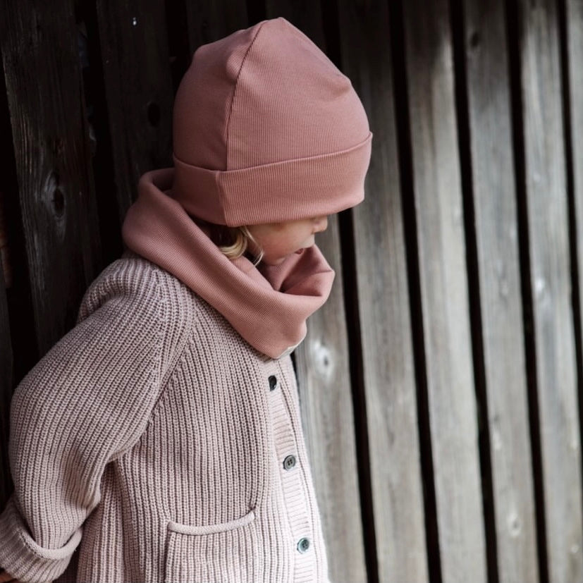 Kuschelig weiche Beanie aus GOTS-zertifizierter Bio-Baumwolle in unserer exklusiven Farbe Dusty Rose.  Die Beanie ist aus fein geripptem und sehr elastischem Stoff, sodass die Mütze mit wächst und Ihr lange Freude daran haben werdet.  Kreiere perfekte Looks indem Du die Beanie mit unseren Schühchen, Leggings und Schals kombinierst!